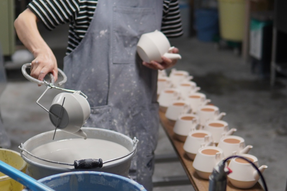 ヤマツさんのコンセプトを最も体現しているのが、自社オリジナルブランドの茶器シリーズ「Frustum（フラスタム）」の土瓶の開発エピソードです。泥を型に流し込む「ガバ鋳込み」という製法で作られる同シリーズを担うのは、外注先である83歳の熟練職人のおじいさんです。かつてこうした手仕事の外注費は買い叩かれるのが産地の常識であり、職人の後継ぎが育たない一因となっていました。